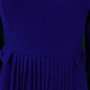 Detail of navy blue pleated dress featuring high waist cut and decorative button pockets