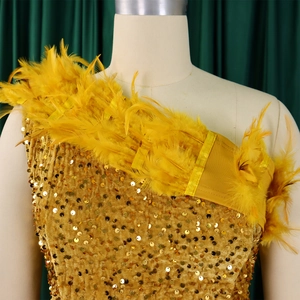 Detailansicht der gold glänzenden Pailletten und Straußenfedern an einem glamourösen Abendkleid