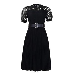 Detailed view of elegant black dress featuring lace splicing and a pleated skirt design