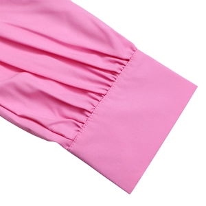 Close-up of pink long-sleeved dress cuff featuring pleated details and precise stitching