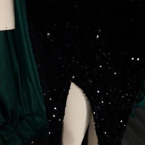 Detailansicht der schwarzen Pailletten und des hohen Schlitzes am Abendkleid