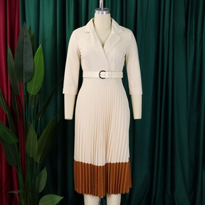 Détail d'une élégante robe plissée crème avec col à revers et ceinture assortie