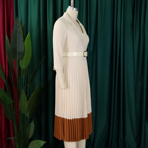 Détail d'une robe plissée élégante avec col à revers et ceinture à boucle dorée chic