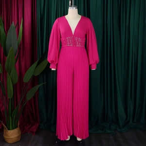 Dettaglio della tuta fucsia con scollo a V profondo e decorazioni con borchie argento
