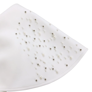Detailopname van witte stof versierd met delicate kralen en zilveren pailletten