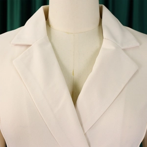 Vue détaillée du col à revers cranté sur un blazer professionnel de couleur crème