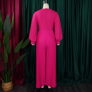 Dettaglio della tuta fucsia a gamba larga pieghettata con polsini decorati da perline