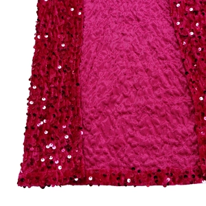 Nahaufnahme von rosarotem Paillettenstoff mit Plisseetextur und glänzenden Details