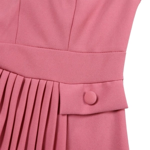 Detail of pink pleated skirt hem and waistline with matching fabric button decoration