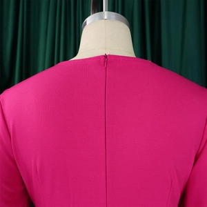 Dettaglio di una tuta fucsia con tessuto strutturato e cerniera posteriore a scomparsa