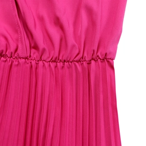 Detail of rose red pleated dress featuring elastic waist and fine vertical pleats