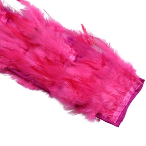 Detailansicht der leuchtend magentafarbenen Federn und passenden Stoffkanten am Abendkleid