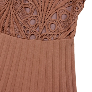 Detail of elegant lace patchwork and fine pleated fabric in brick red evening dress