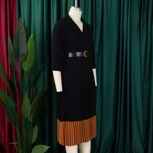 Détail d'une robe plissée élégante avec ceinture noire et boucle dorée raffinée