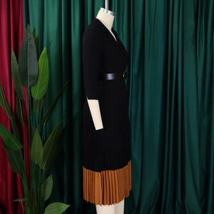Détail d'une robe élégante plissée bicolore avec col tailleur et ceinture noire
