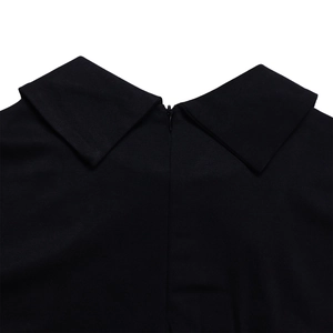 Détail d'une robe noire élégante montrant un col pointu et une fermeture éclair invisible