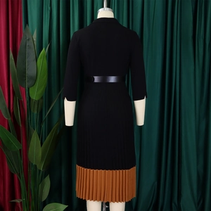 Détail de robe noire pour femme avec ourlet plissé marron et fine ceinture à la taille