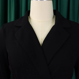Gros plan détaillé d'une robe blazer noire avec col à revers et décolleté en V précis