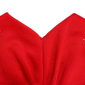 Detailopname van een rode jurk met V-hals, blinde rits en kralen op de schouders