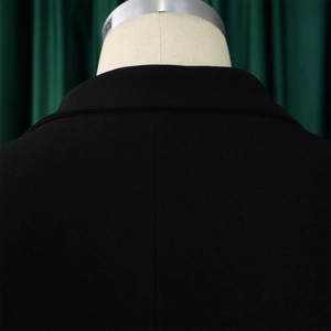 Détail du col de blazer noir élégant et coutures d'épaules sur robe en tissu texturé
