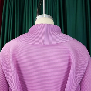 Dettaglio del top a pieghe lavanda con micro texture orizzontale e finitura del collo alto