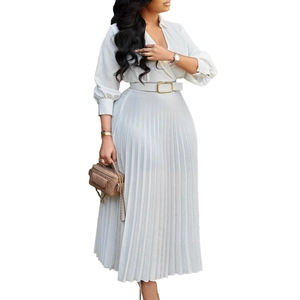 Detail of elegant white pleated maxi dress featuring a V-neck wrap top and gold-buckle belt