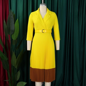 Détail d'une robe plissée à col en V avec un design color-block jaune moutarde et marron