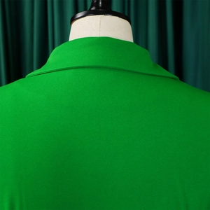 Detailopname van de felgroene reverskraag en fijne stoftextuur op een vrouwelijke pop