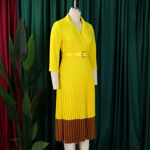 Détail de la robe plissée avec col à revers jaune et boucle de ceinture assortie