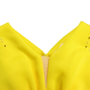 Detail van gele jurk met V-hals voorzien van parelversiering op de schouders en textuur stof