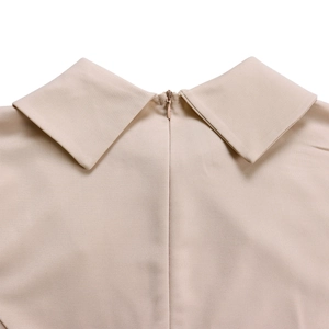 Détail du col pointu de la robe beige avec fermeture éclair invisible de qualité