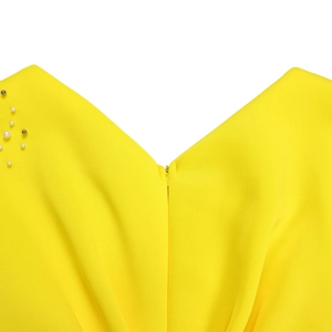 Detail van de V-hals met faux-parels en verborgen rits op de felgele jurk