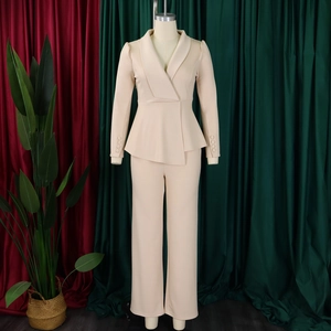 Detail of beige peplum blazer suit showing the tailored waist and elegant ruffles