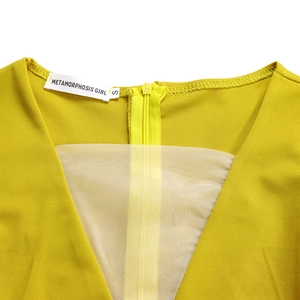 Dettaglio dello scollo a V giallo senape con inserto in rete trasparente e cerniera