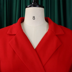 Detail van de rode blazer met gestructureerde revers en hoogwaardige stoftextuur