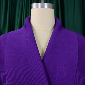 Dettaglio del top a pieghe viola scuro con scollo a V e trama a micro pieghe sottili