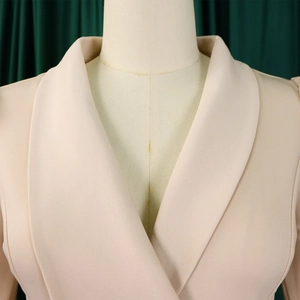 Detail of elegant shawl lapel on a beige blazer with professional woven fabric texture