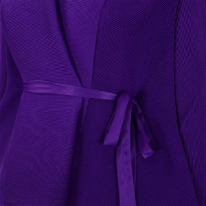 Dettaglio del tessuto plissettato viola scuro con cintura in raso abbinata da donna