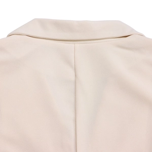 Gros plan du col de blazer beige et des coutures de revers sur tissu tissé