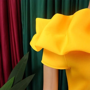 Dettaglio dello scollo a barca giallo vivace con eleganti maniche con balze a volant