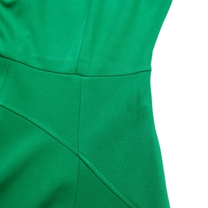 Vue détaillée de la taille d'une robe verte montrant les coutures et la texture du tissu