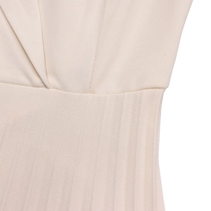 Détail de la robe beige montrant la taille plissée et la texture du tissu fin