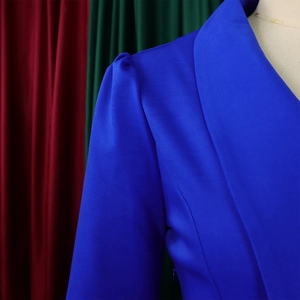Detail of royal blue blazer shoulder with pleated puff sleeve design on a white mannequin
