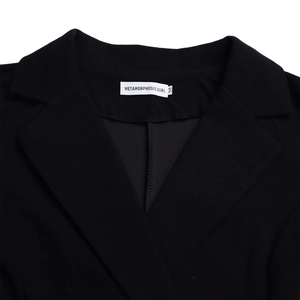 Vue détaillée du col de blazer noir avec étiquette de marque blanche et taille M