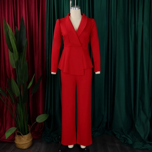Detail of red business suit featuring asymmetrical peplum hem and buttoned long sleeves