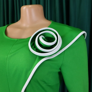 Detail of the oversized white spiral floral appliqué on this green knit pencil dress