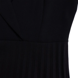 Détail du décolleté en V élégant et des plis verticaux raffinés sur une robe noire