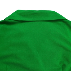 Detail van een groene jurk met kraag toont fijne geplooide stofstructuur en afwerking