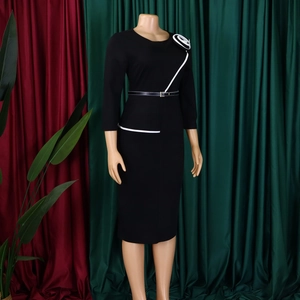 Detail of elegant pencil dress with contrast piping, floral brooch and waist belt