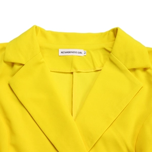 Détail du revers d'un élégant blazer jaune avec coutures de qualité et étiquette taille M